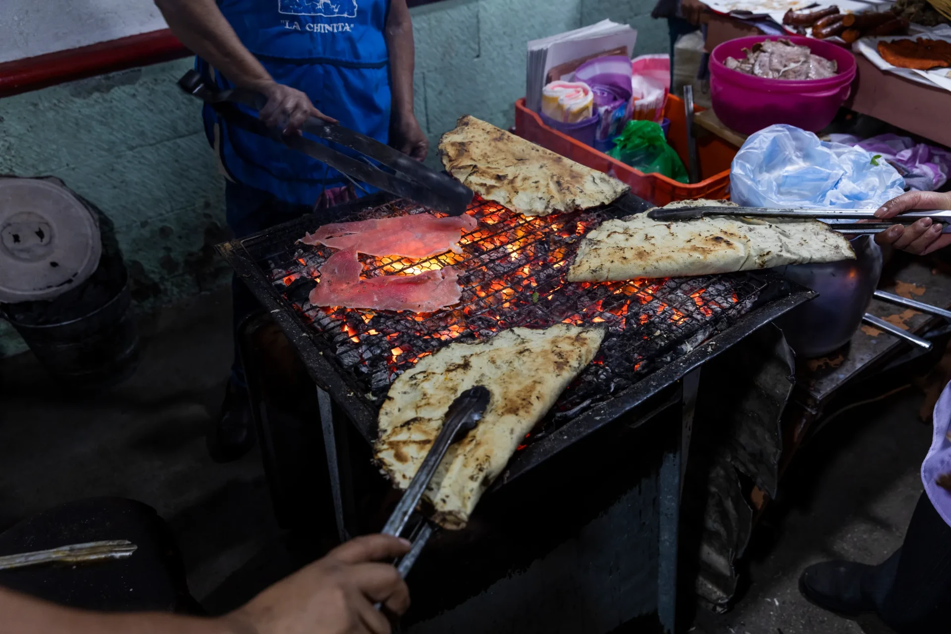 Tlayudas oaxaqueñas y tasajo asándose al carbón en un comal tradicional